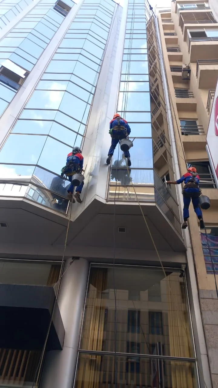 Cordistes nettoyant la façade d’un immeuble en hauteur à Casablanca